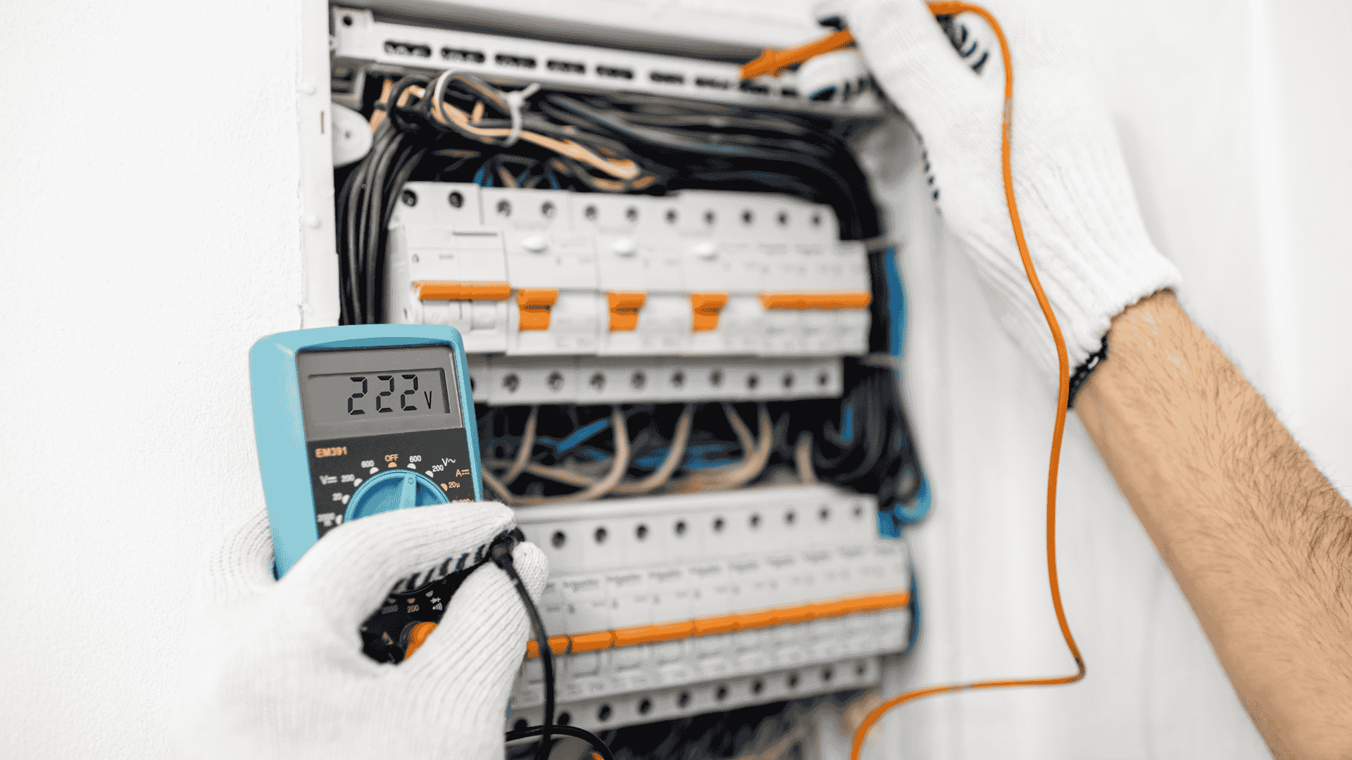 Electrician testing voltage inside electrical panel during home electrical inspection